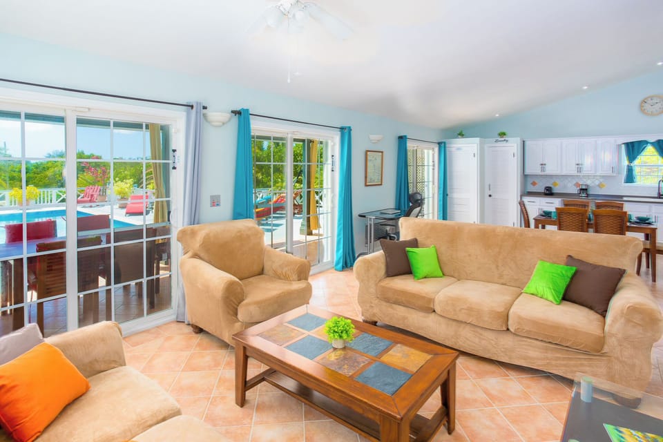 Indoor living space featuring large sliding glass doors facing deck and pool
