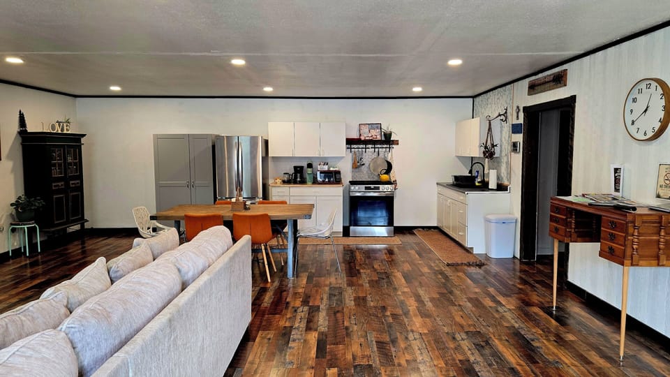 microwave, kitchen visible, interior, indoor, coffee and or coffee maker, oven, couch, refrigerator, living area, stovetop, dining table