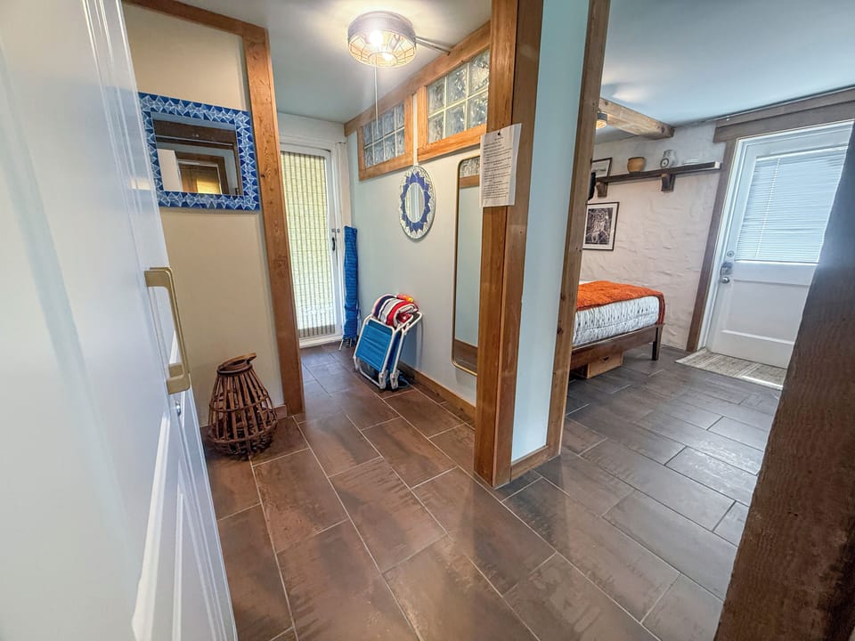 Bright tiled hallway with beach essentials and full length mirror