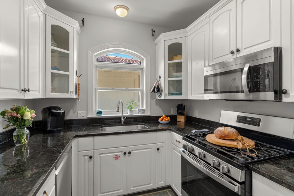 Bright white cabinetry paired with sleek, dark granite countertops.
