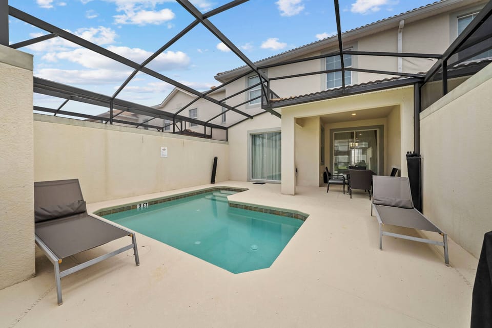 Step outside to enjoy your private splash pool, framed by a sleek screened enclosure that keeps the sun shining on your relaxation time. Comfortable loungers invite you to unwind while you soak in the serene atmosphere.