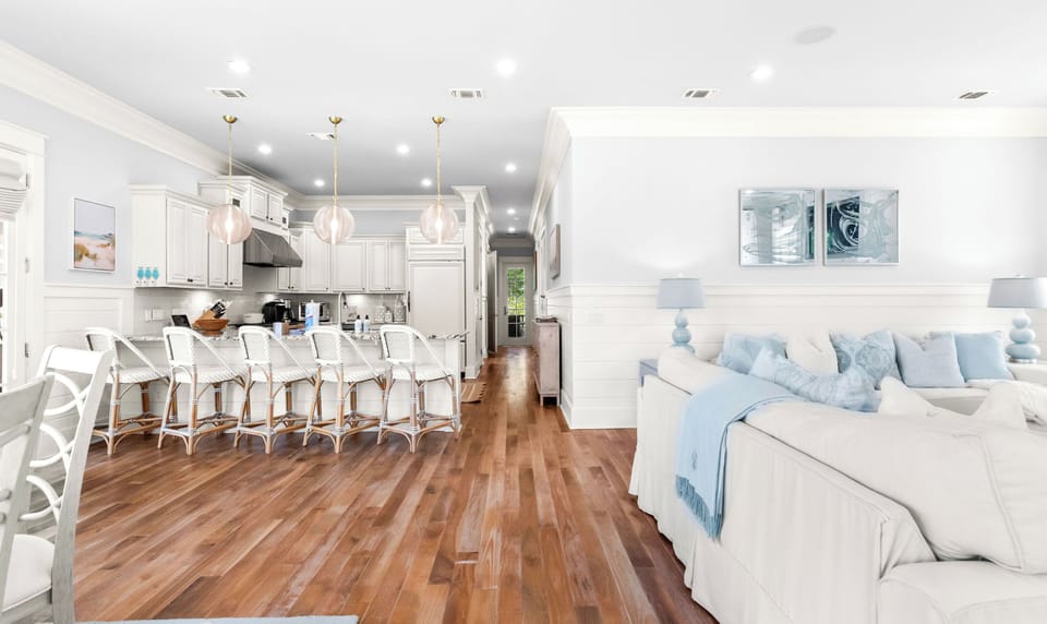 Picture yourself in this bright, open living space where coastal-inspired décor meets modern comfort. Soft blues and whites create a serene retreat, perfect for relaxing after beach days.