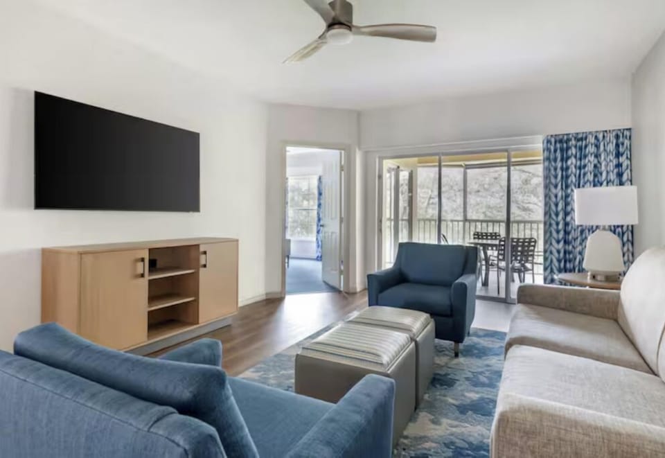 Relax in the airy living room steps from the balcony.