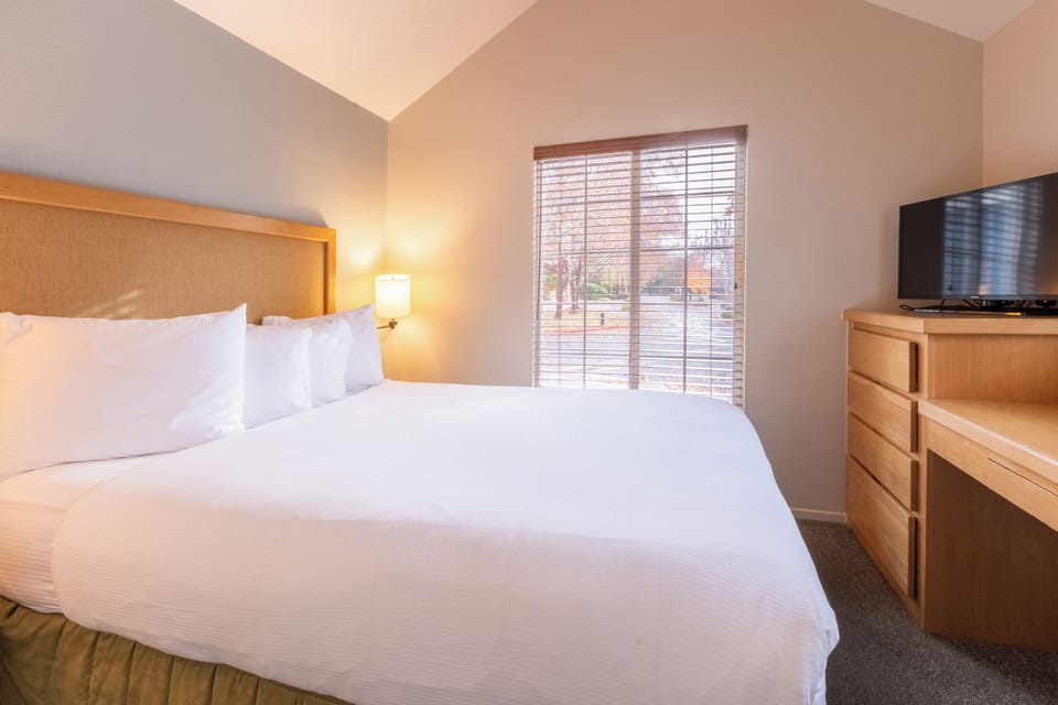 Stretch out in a spacious bedroom with TV and warm lamplight.
