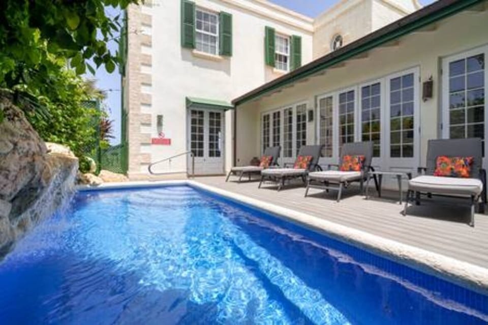 The private swimming pool is positioned to the side of the property and is flanked with plenty of sun loungers and seating.