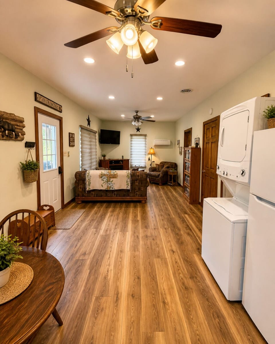 Spacious rustic cabin interior with open living area, wood floors, cozy seating, and in-unit washer and dryer
