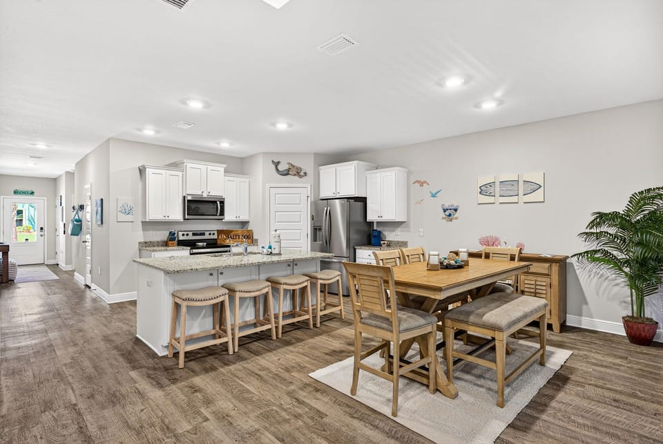 Gather around the spacious kitchen island and dining table where your group can cook together, share meals, and make memories in this bright, welcoming space with modern appliances and coastal charm.