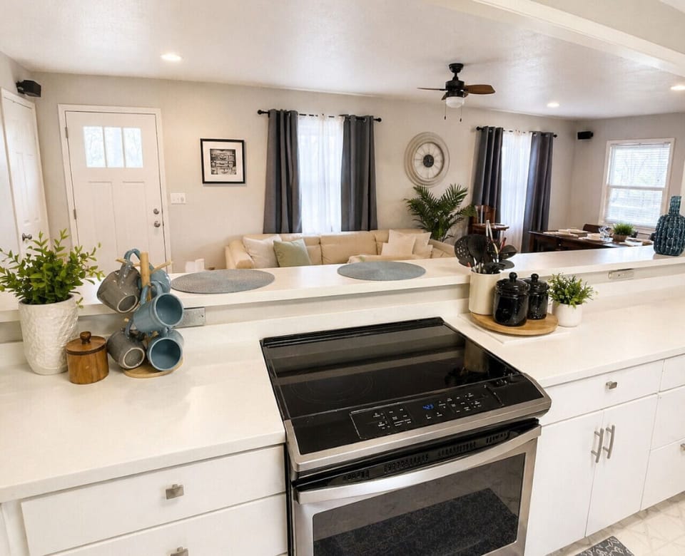 Modern open-concept kitchen with updated appliances and breakfast bar overlooking the living area—perfect for cooking, entertaining, and comfortable family stays.