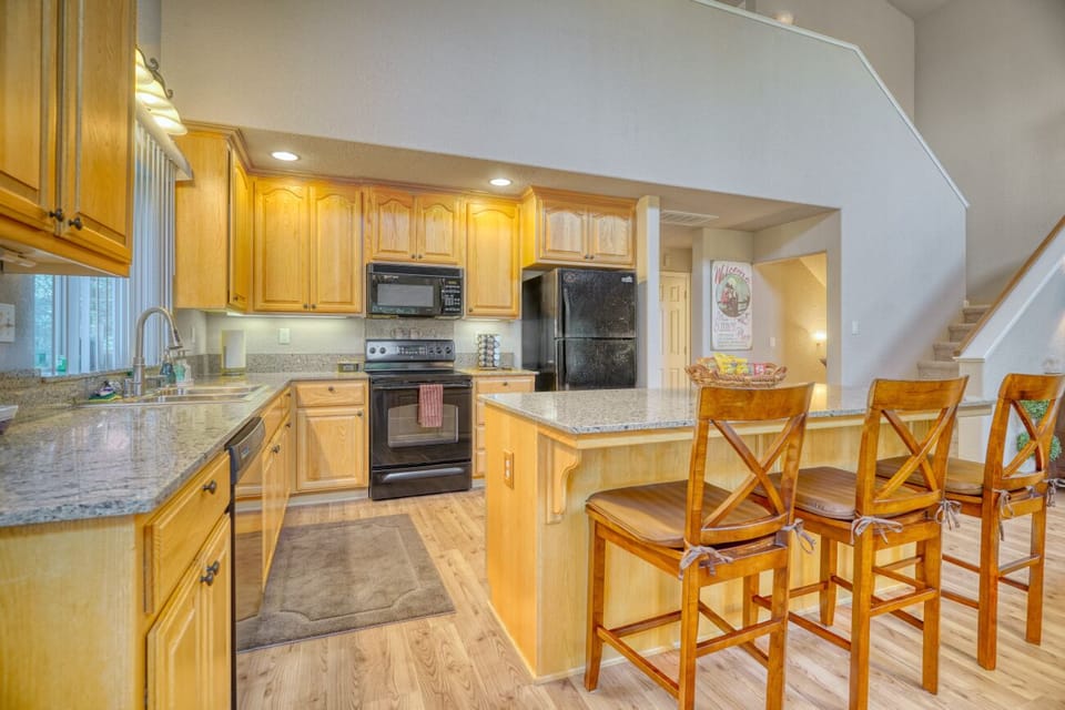 Bright open kitchen with granite counters and island seating for three
