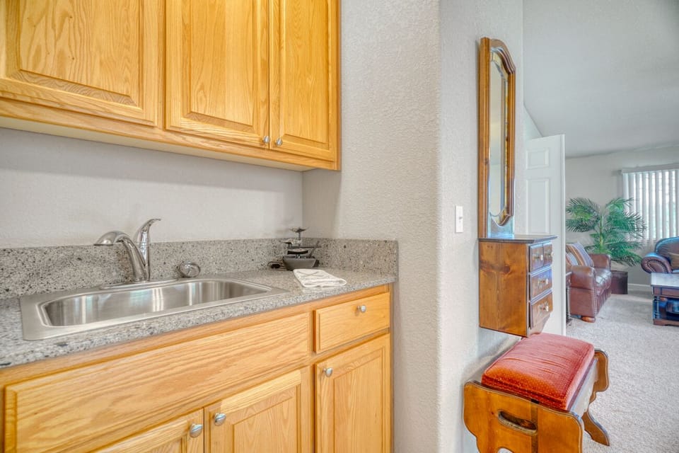 Convenient wet bar with warm wood finishes beside a cozy living area