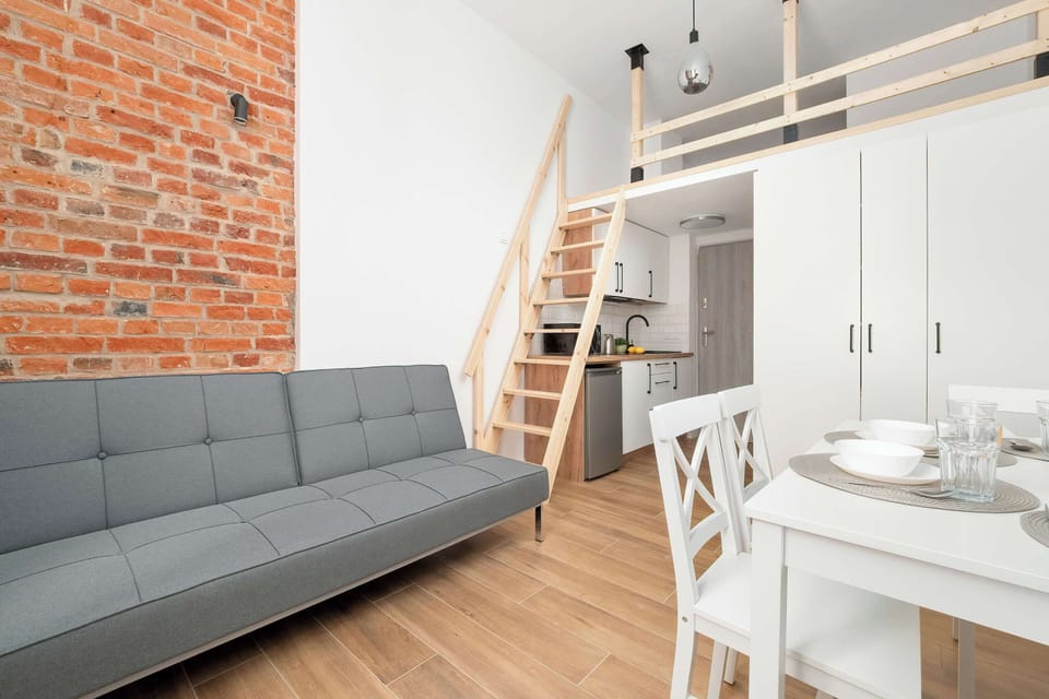 The living area features a sleek table and a flat-screen television.