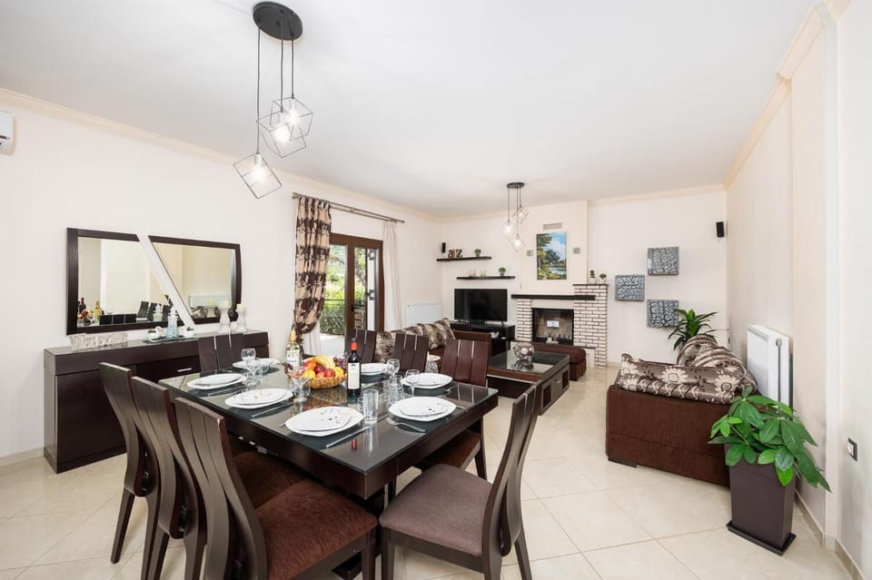 Open-plan living room with sofas, dining area, kitchen, ornamental fireplace, A/C, WiFi internet, and satellite TV