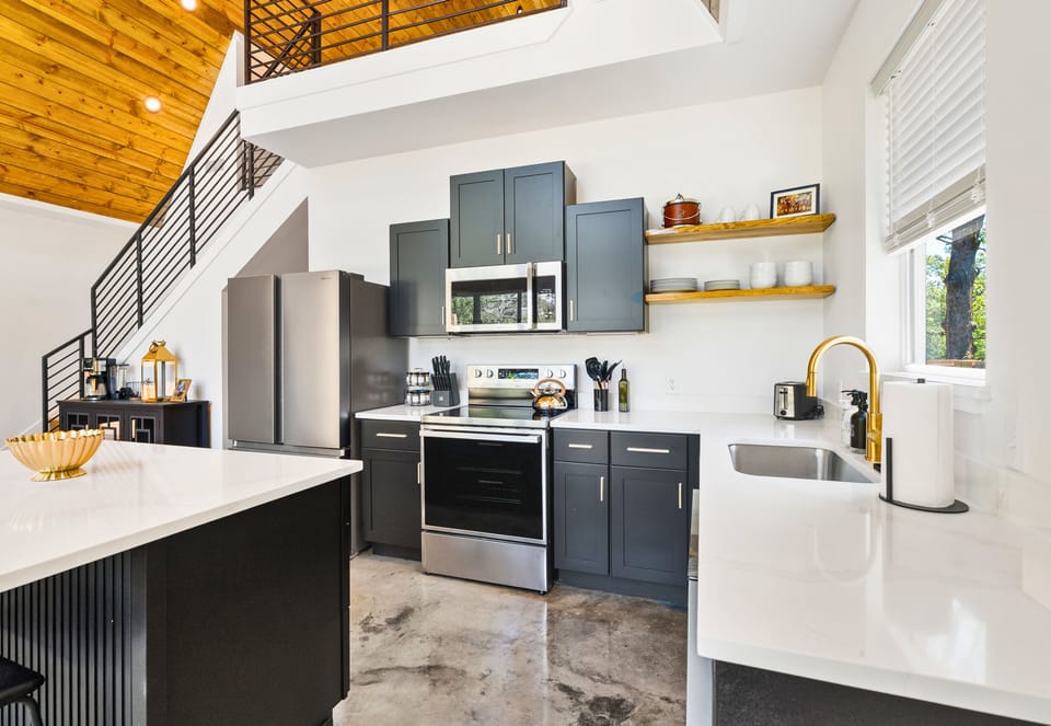 The chef's kitchen features a farmhouse sink, gold fixtures, and everything you need to whip up something special or keep it super simple.