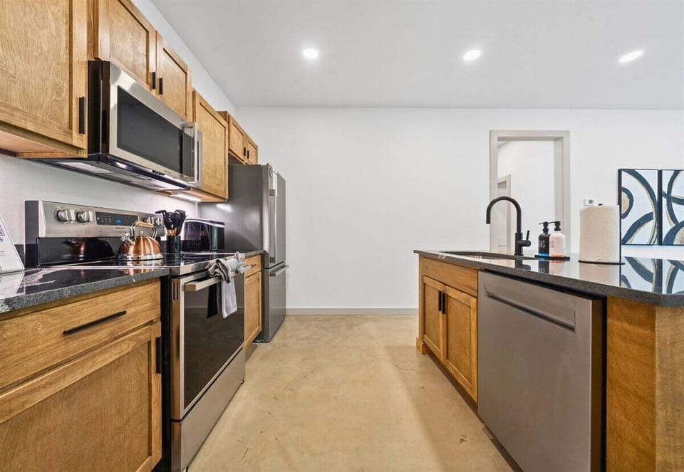 Spacious, modern kitchen with stainless appliances and a big island for coffee, snacks, or prep.