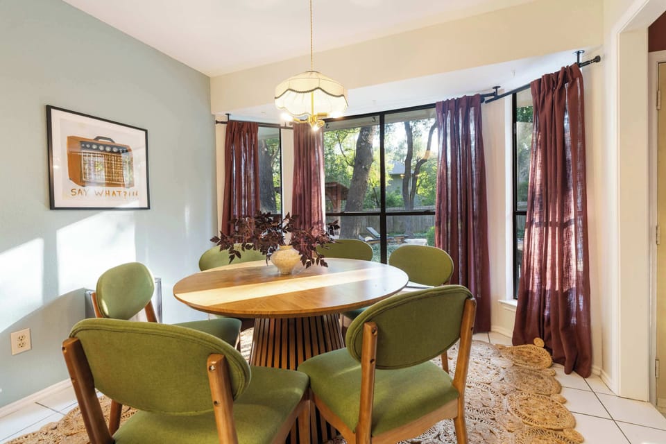Gather around the table with natural light pouring in and lush greenery just outside — the perfect setting for relaxed meals and great conversations.