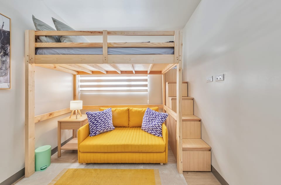 Space-saving loft bed with cozy sofa and cheerful modern accents