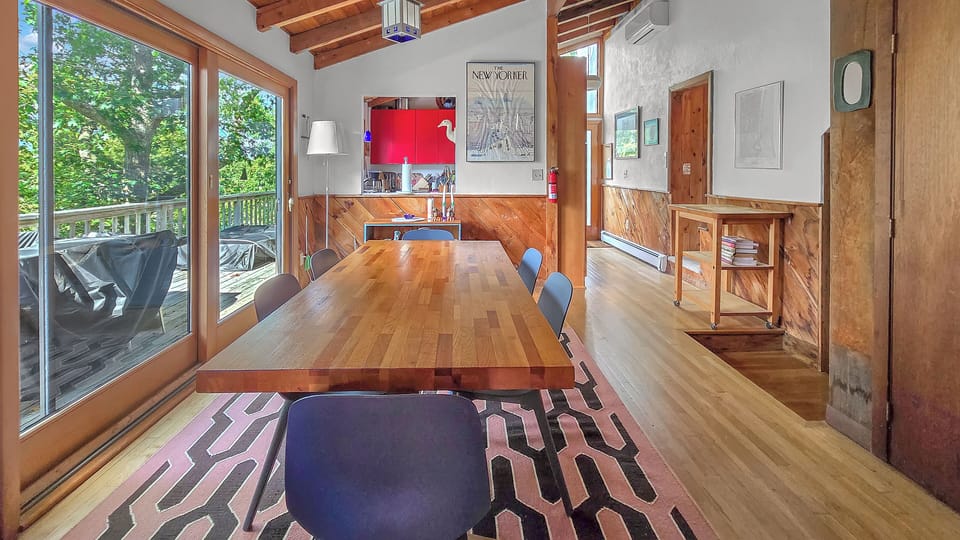 Dining room with large table between kitchen and living room