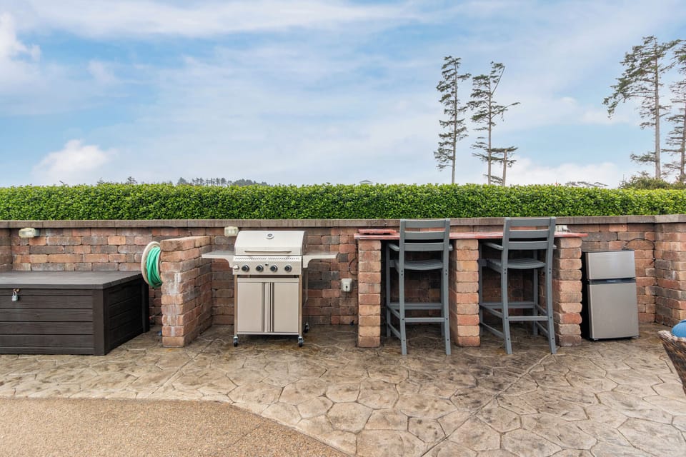 Private patio features a full-size grill, bar seating, and mini fridge—your perfect spot to savor sunny meals and evening drinks outdoors in complete comfort.