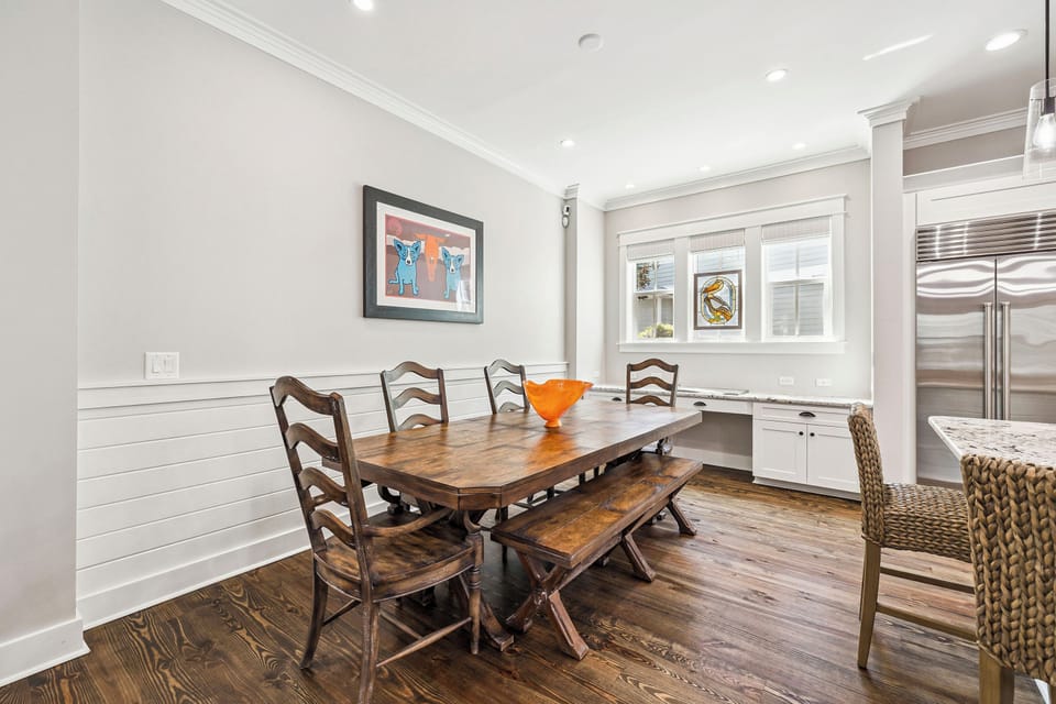 Gather around the warm wood table where your mornings begin with coffee and conversation. Natural light fills the bright space, inviting you to linger over meals together.