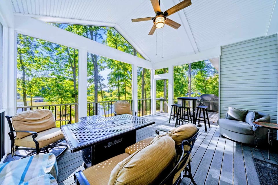 Balcony Deck - Screened porch with vaulted ceiling, propane fire pit table, and bar-height seating overlooking the cove. The most-used room of the house.