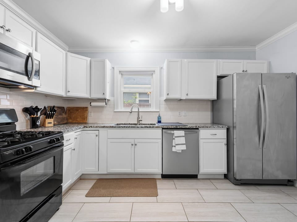 Bright kitchen with a gas stove, dishwasher, refrigerator, and plenty of space.