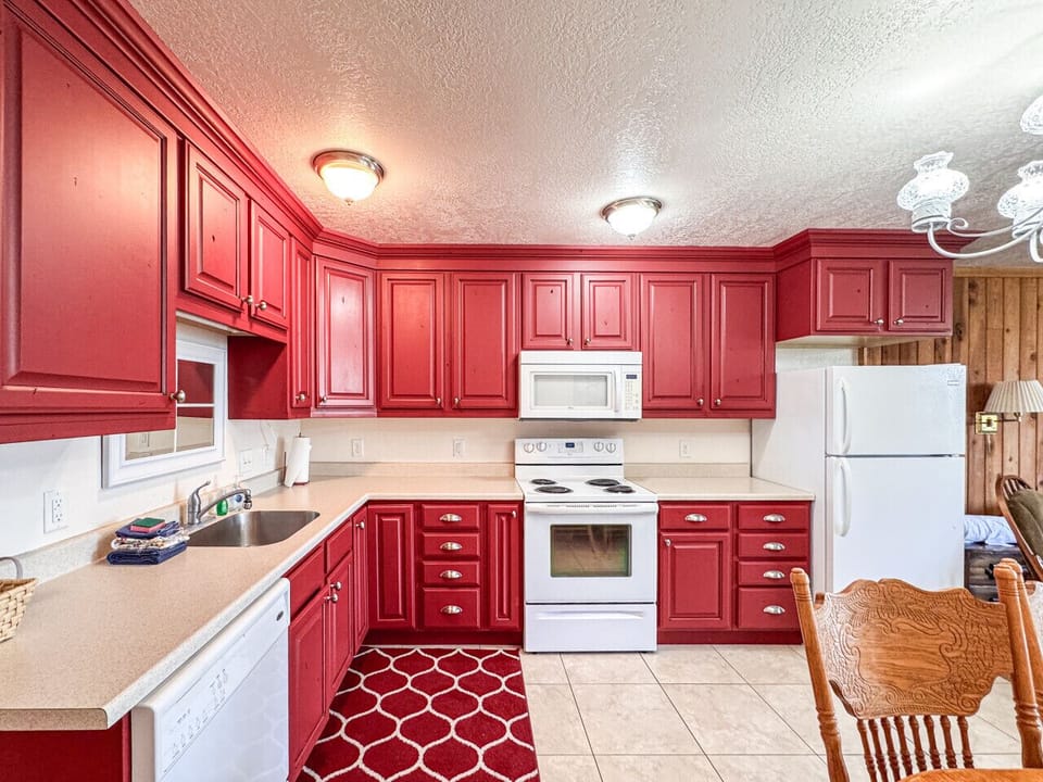 Cheerful kitchen with vibrant cabinetry and spacious layout, perfect for memorable family meals.