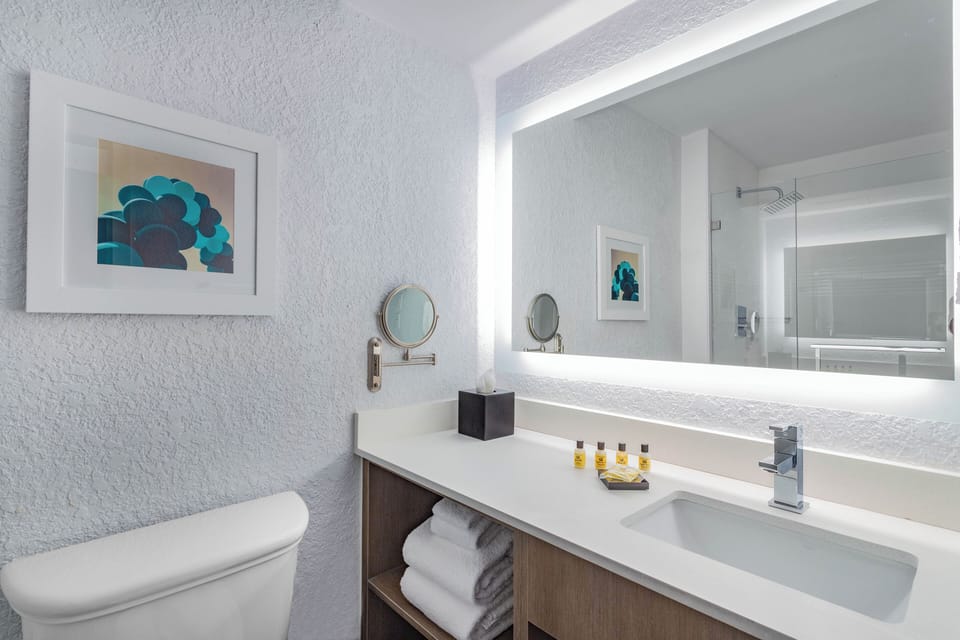 Refresh at a sleek vanity with bright mirror lighting.