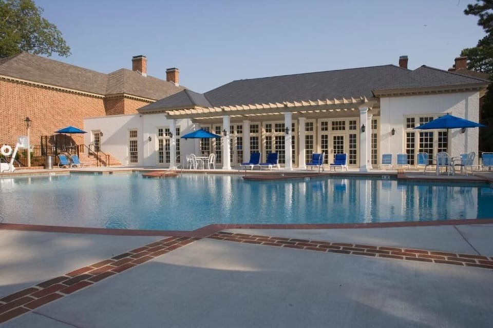 Dive into sunlit serenity beside a sparkling resort-style pool.