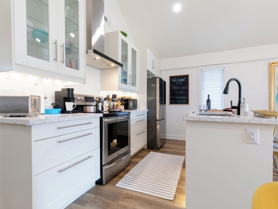 Kitchen with stove, coffee maker, dishwasher, microwave, toaster