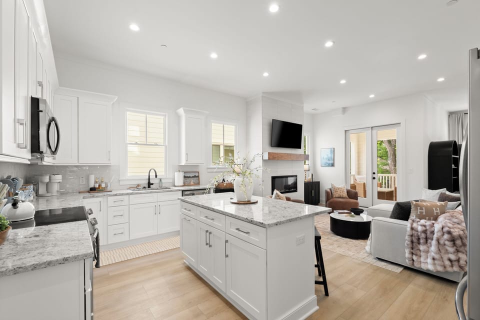 Bright open kitchen + cozy living room with fireplace and outdoor access