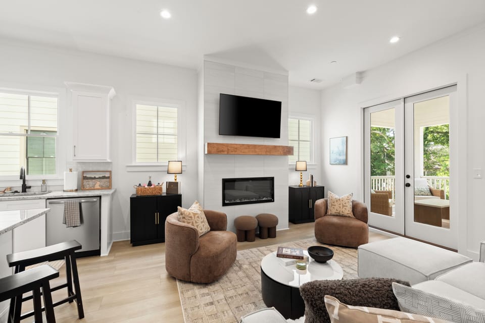 Bright modern living room with fireplace, TV, and patio access
