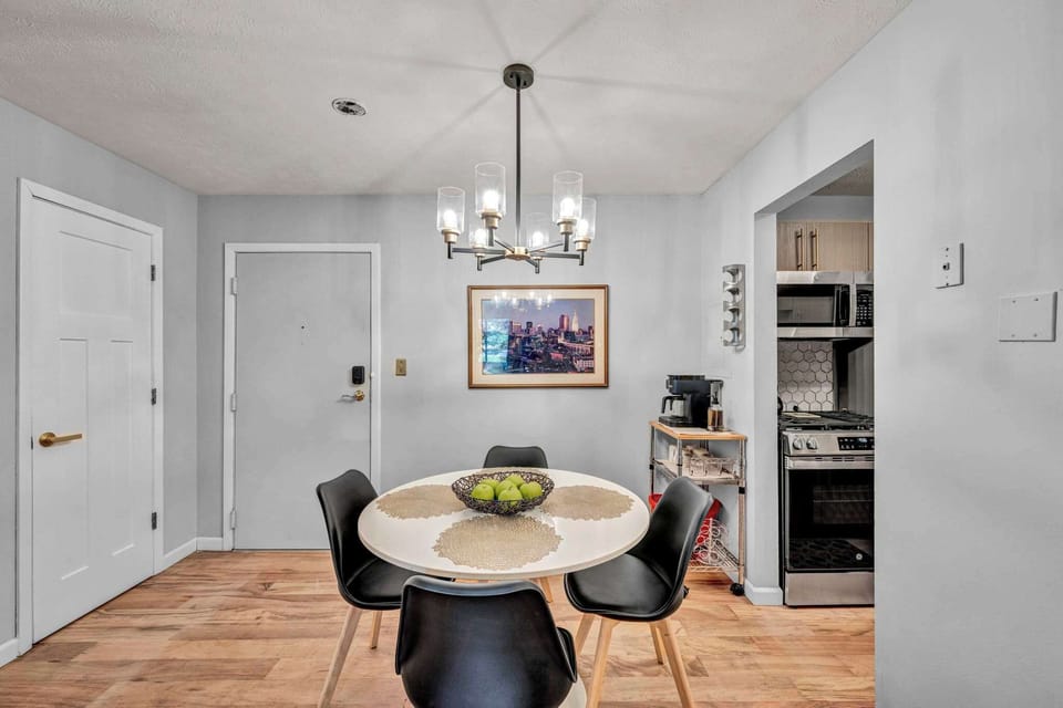 Dining room w/ round table, chairs & statement chandelier overhead.