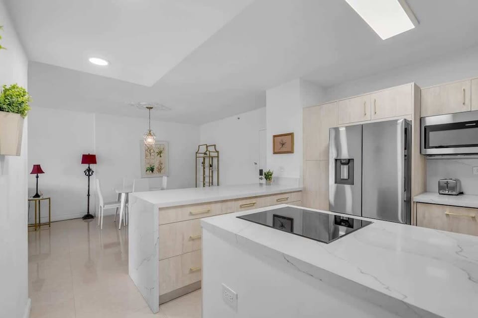 Fully equipped modern kitchen with stainless steel appliances, generous counter space and breakfast bar — everything you need for a home-cooked meal