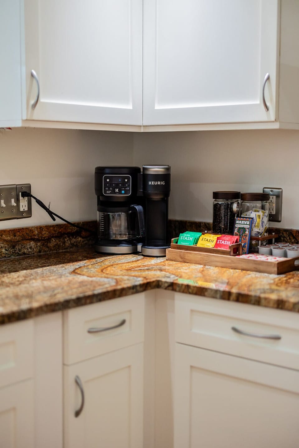 Coffee station stocked with a Keurig, teas, and granite countertops for your morning routine