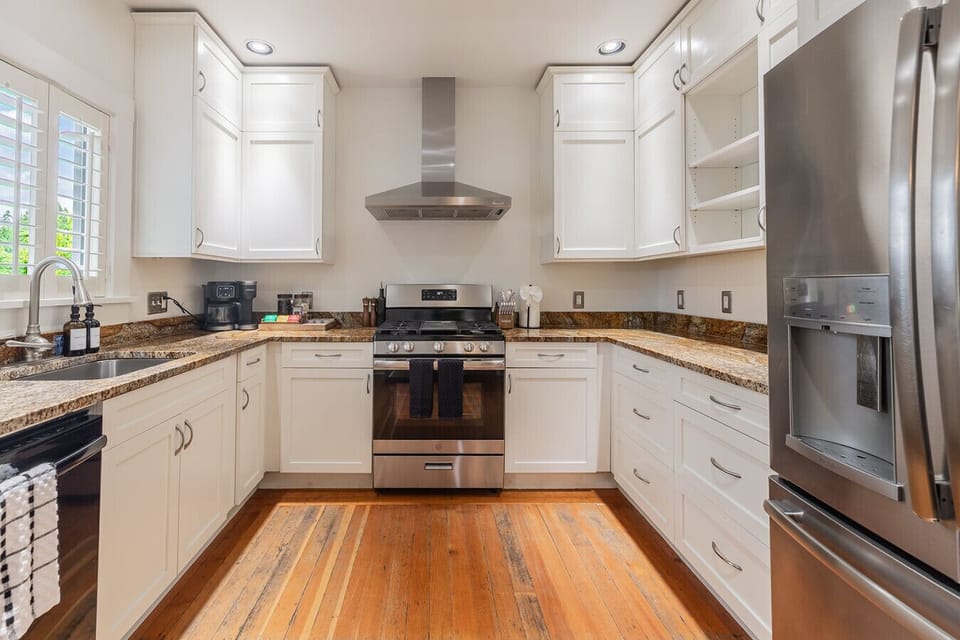 Well-equipped kitchen with white cabinetry, gas range, and stainless steel appliances