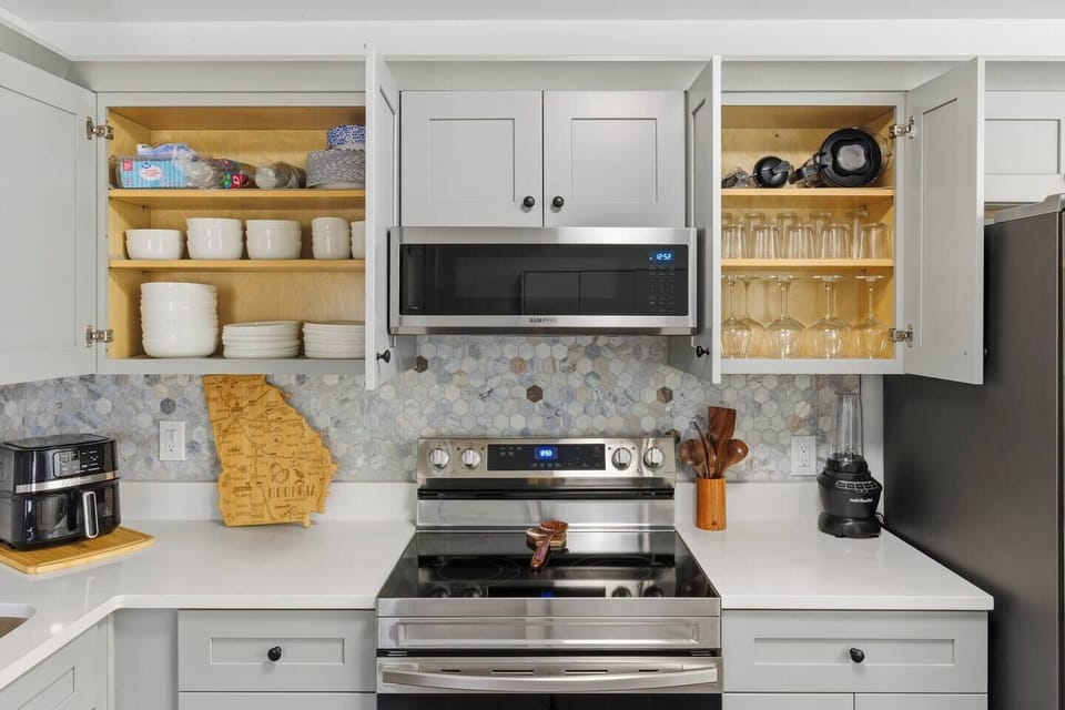 This fully stocked chef-style kitchen features stainless steel appliances, sleek cabinetry, and all the essentials—from cookware to glassware. Thoughtfully arranged for convenience, it's directly across from the laundry for a seamless flow.