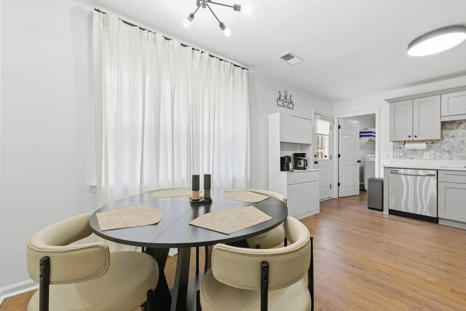 The open-concept living area flows into a modern, chef-ready kitchenette—featuring stainless steel appliances, a full coffee bar with Nespresso + Mr. Coffee drip options, wide windows, and chic finishes designed for comfort, cooking, and connection.