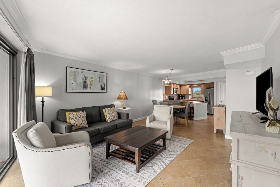 Relax in the Gulf-view living room with balcony access, coastal décor, and comfortable seating.