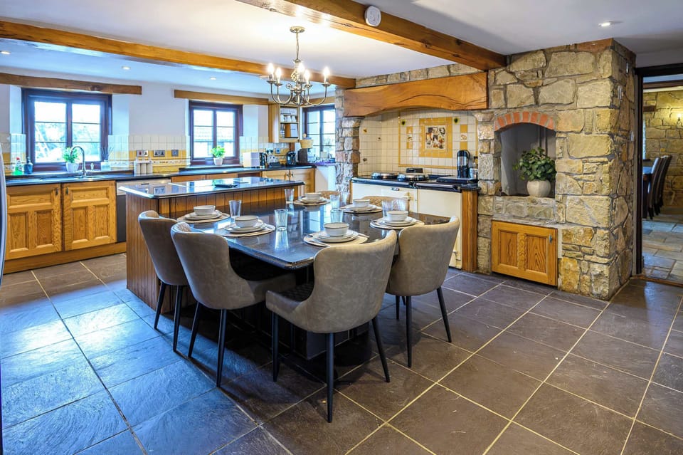 Fully equipped Kitchen for modern entertaining, including a cooker and hob, generous preparation space, a large fridge-freezer, coffee machines, and extensive cookware.