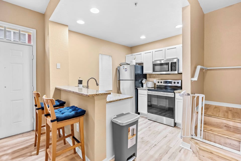 Welcome to this charming kitchen with sleek stainless steel appliances and warm, light walls that create a cozy vibe. The inviting breakfast bar with sturdy stools is ideal for enjoying casual meals and your favorite culinary.