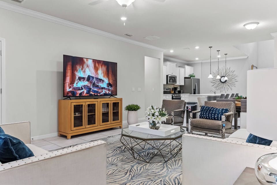 Relax in this bright, airy living area after your adventures. Enjoy the cozy fireplace, large TV, and tasteful decor, all designed for your comfort and relaxation in this inviting modern space.