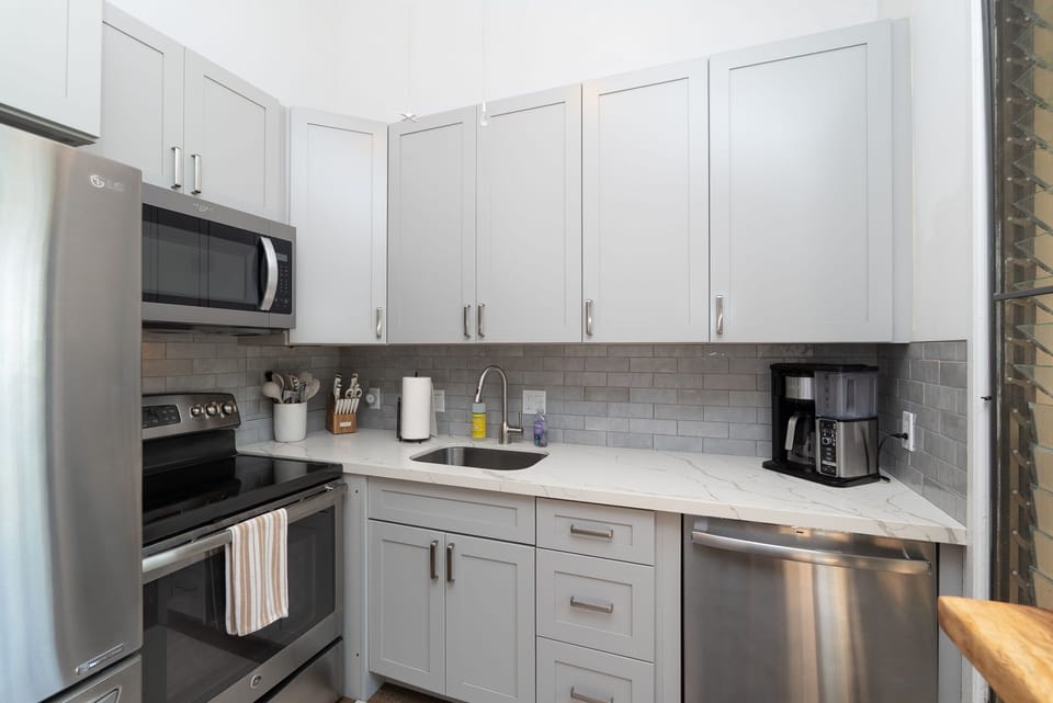 Cook your favorite meals in this bright, fully equipped kitchen with modern appliances and elegant marble countertops for your comfort.