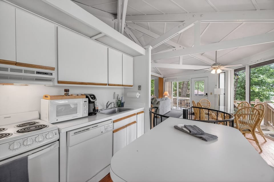 Picture yourself cooking in this bright open kitchen with vaulted ceilings and abundant natural light streaming through large windows overlooking lush greenery.