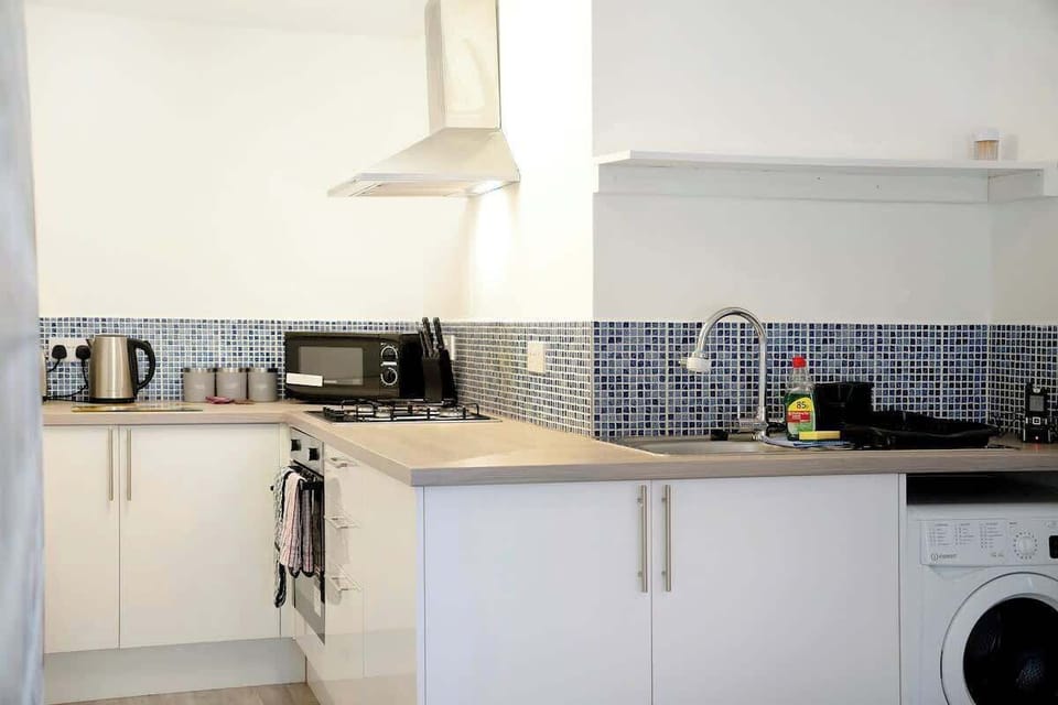 Kitchen equipped with all essentials, including a washer & dryer, oven, fridge and full cookware set.