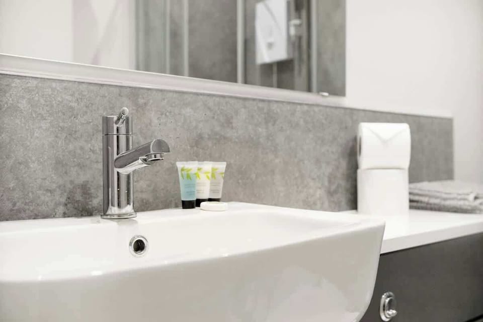 The bathroom benefits from an overhead shower, toilet and a sink. 