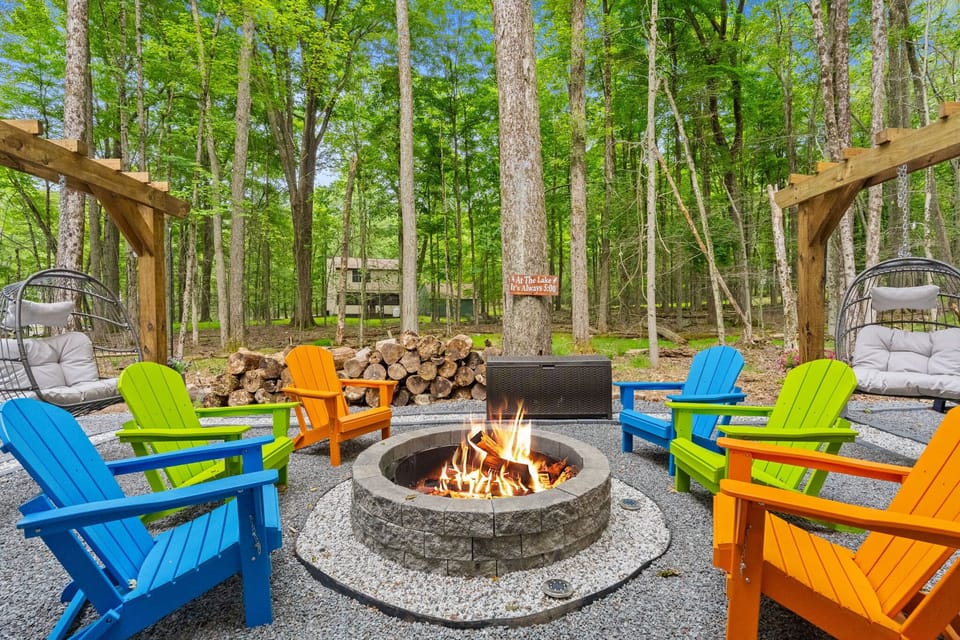 Colorful Adirondack chairs surrounding private fire pit in the Pocono woods