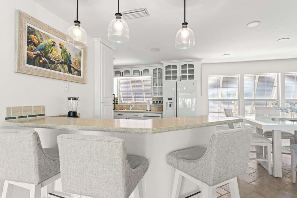 Stylish coastal kitchen and dining area. Gather around the spacious island, enjoy home-cooked meals, and relax in this bright open-concept space designed for comfort, connection, and unforgettable vacation memories!