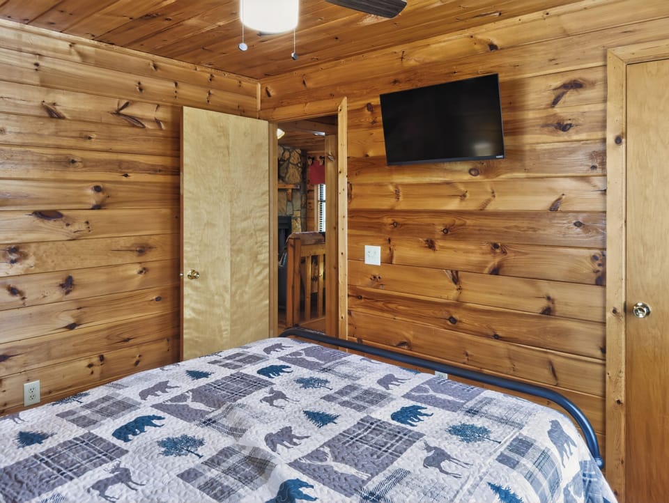 Main level queen bedroom with ceiling fan and smart TV