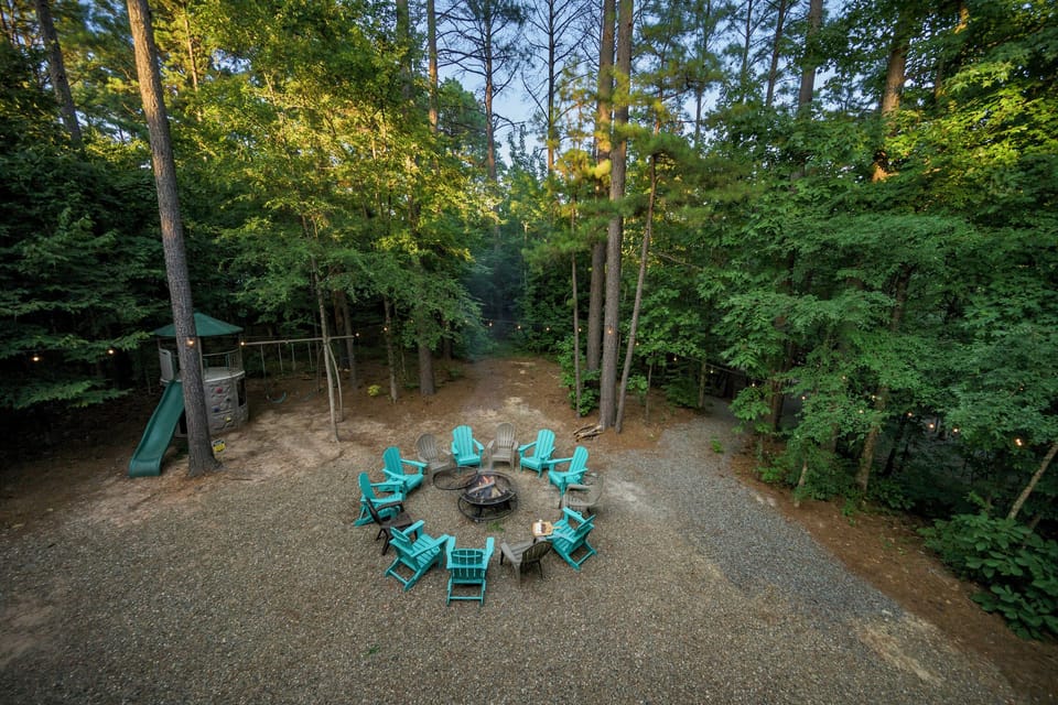 Private wooded fire pit area with Adirondack chairs and family-friendly playset