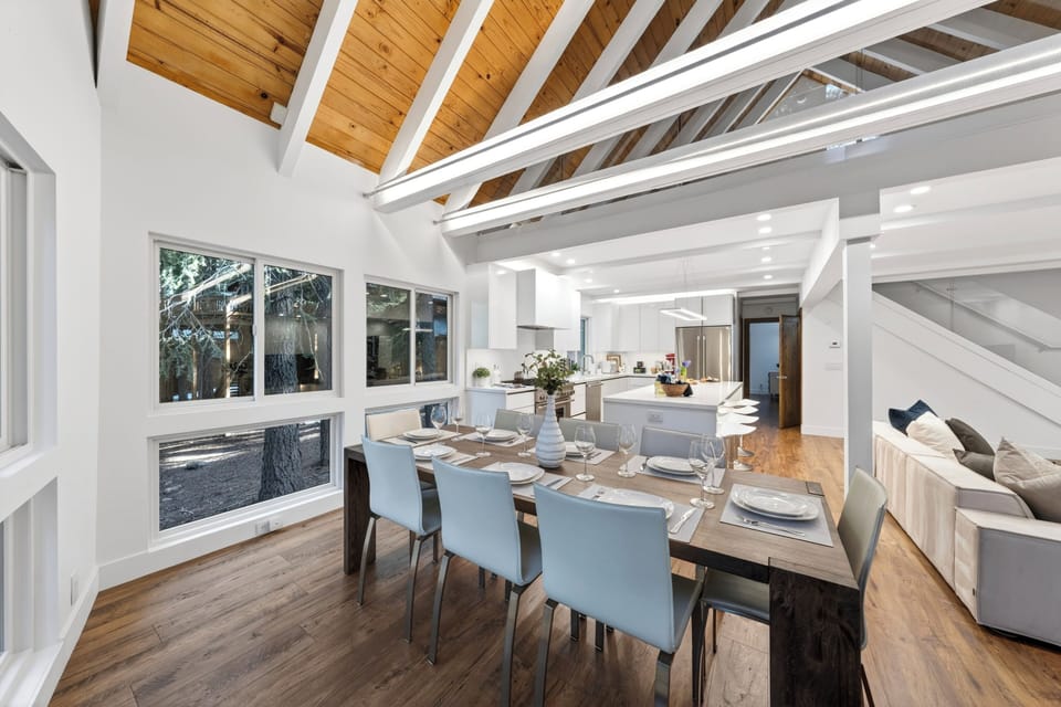 Natural light floods the dining space, highlighting the beautiful wood-beamed architecture